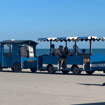 A small blue tourist train with people riding, parked by the seaside under a clear blue sky. Websites For Accountants UK That Build Trust